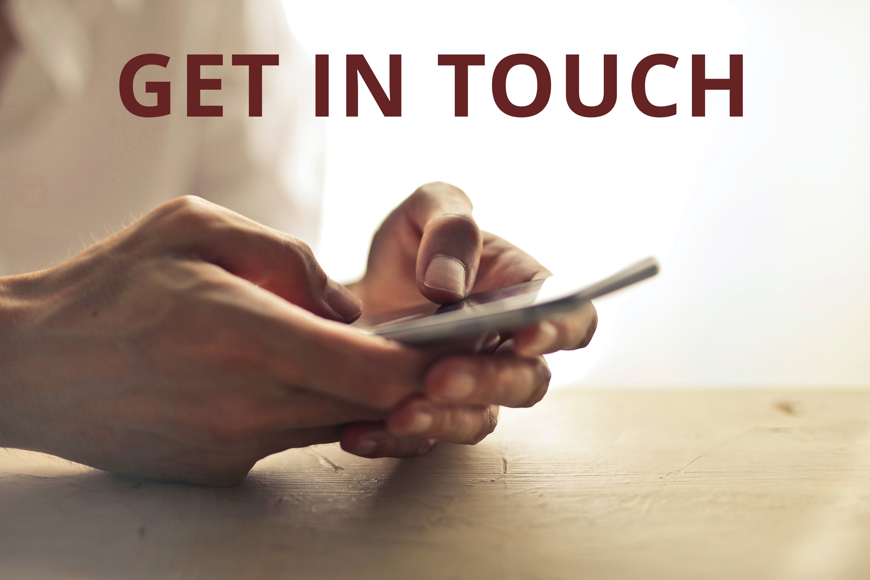 graphic of someone holding a phone with the caption "GET IN TOUCH"